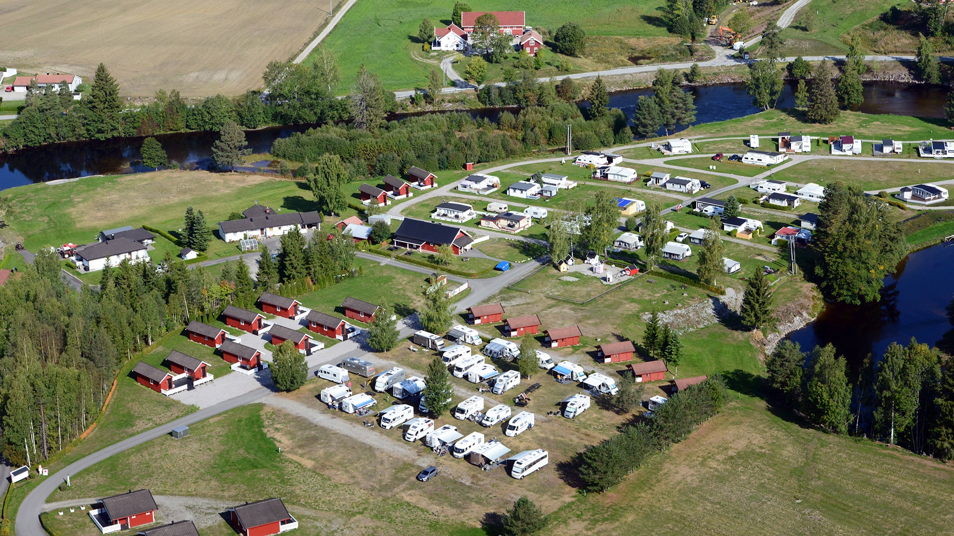Spacious tent and camping pitches at Sanda Camping in Bø, Telemark - idyllic location by the Bøelva river with modern facilities, free WiFi and a short distance to outdoor adventures.
